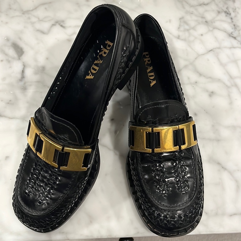 Black Prada loafers with gold buckle